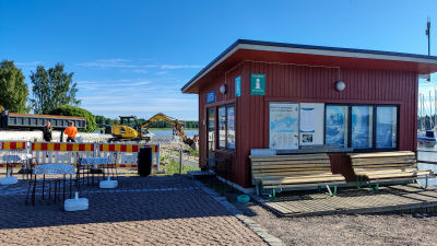 Ett litet rött trädhus vid en gästhamn.
