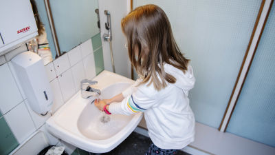Ett skolbarn tvättar händerna.