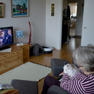 bild på en kvinna som tittar på tv med hennes katt