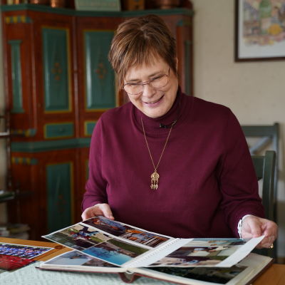 Eva Sparv bläddrar i ett fotoalbum