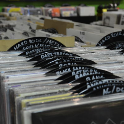Hyllor fyllda med vinylskivor organiserade efter genre.