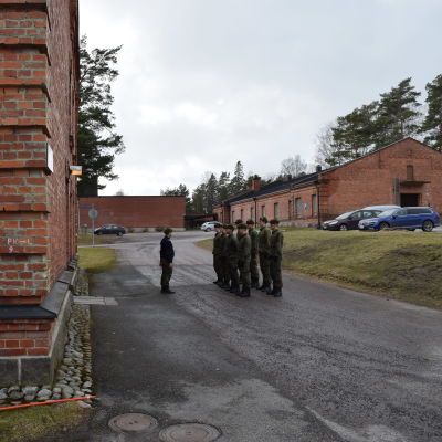 Beväringar utanför byggnad på Nylands brigad.