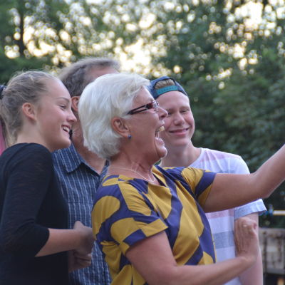Farmor och farfar tar gruppselfie med sina barnbarn.