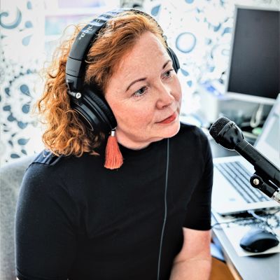 Heidi Finnilä sitter framför en mikrofon