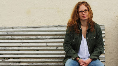 Maria Österåker sitter på en bänk