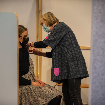 Sairaanhoitaja pistää koronarokotteen potilaalle Energia Areenalla Vantaalla. 26.5.2021.