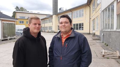 Två killar framför renoveringsobjekt