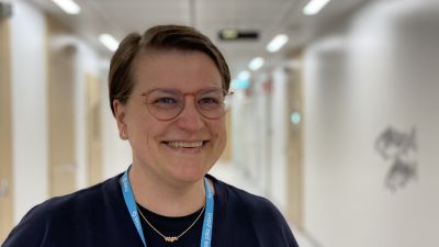 Glad kvinna tittar in i kameran.