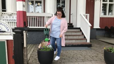 Minna Ohvo vattnar blommor utanför Strandkrogen i Nagu