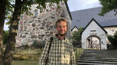 James Simpson, står framför kyrkan i Gamla Malmen i Pargas.