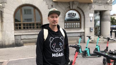 Juha Kuuttila bredvid en parkering för elsparkcyklar.