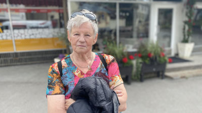 Solveig Ljungberg, en kvinna med kort, grått hår iklädd en tunika i rosa, turkost och orange.