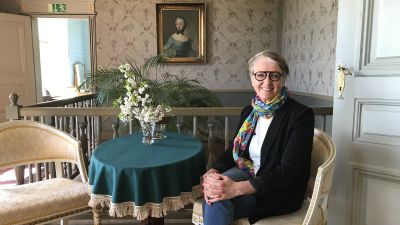 Kaija Hartiala sitter i den gustavianska salen på Brinkhall.