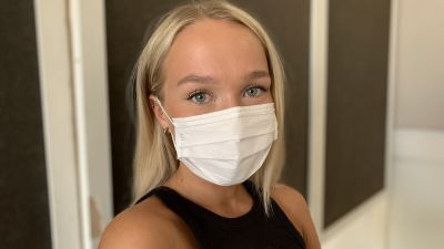 Ung blond kvinna med munskydd väntar på sin tur till drop-in mottagning för coronavaccinering i Malax..