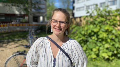 Jutta Maunula, en kvinna med mellanblont uppsatt hår och glasögon, ler mot kameran.