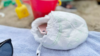 En mobiltelefon är inpackad i en blöja på en strandhandduk.