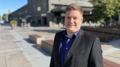 Mansantagen person poserar på torg.