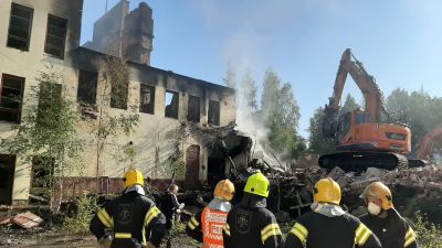 Brandmän och rykande ruin.
