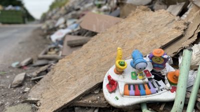 En plastleksak sticker fram i en väldig hög av obestämbart bråte.