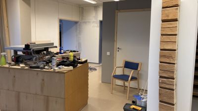 Ett rum där renovering pågår. En arbetsbänk med en mängd verktyg och bråte på.
