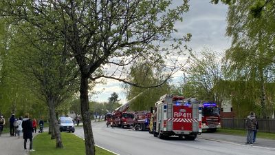 Många har samlats för att se en brand på Hökgatan i Orrnäs i Vasa. Många brandbilar står på rad, på gångvägen står många människor och tittar på. Vår.