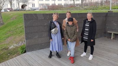 Tre vuxna och en pojke på en utescen.