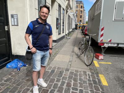 Janne Mäkelä står på en gata i Köpenhamn med en finsk landsladströja.