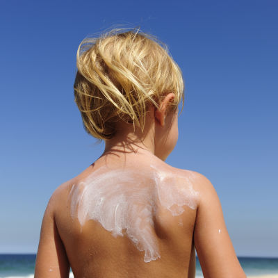 Ett barn i solen på en badstrand