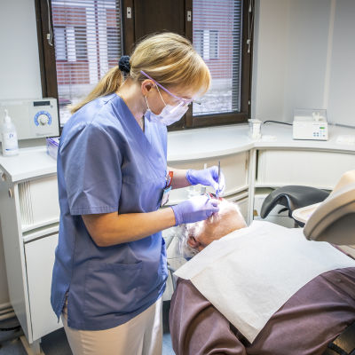 Hammaslääkäri tarkistaa potilaan hampaita.