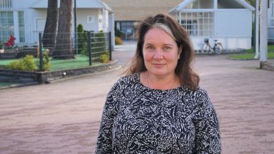 Kvinna i svart klänning står på en innergård.