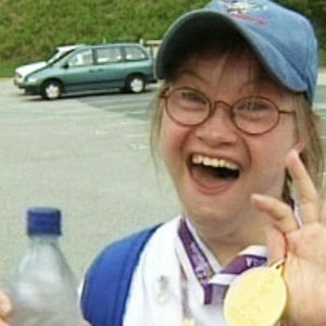 Suomen Special Olympics -joukkueen urheilija näyttää riemuiten mitaliaan.