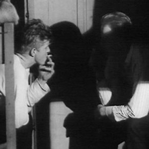 Metsätyömiehet rentoutuvat tupakan äärellä savottamajassa 1966.