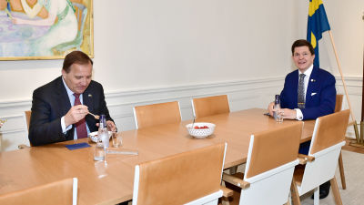 Stefan Löfven och Andreas Norlén vid ett långt bord. De äter jordgubbar.