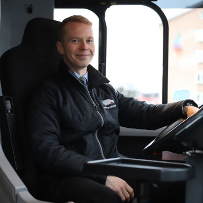 Kemin Taksipalvelun yrittäjä Juha-Matti Rissanen istuu bussissa kuskin paikalla.