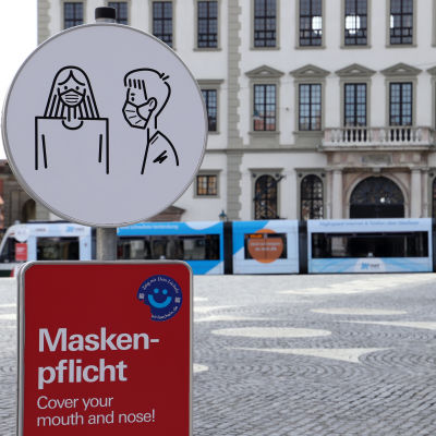 Skylt infomerar om att det är obligatoriskt att bära munskydd utanför rådhuset i Augsburg