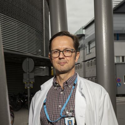 Läkaren Matti Reinikainen utanför en sjukhusbyggnad. 