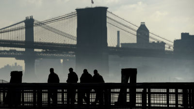 Dimma över Brooklyn Bridge med några män i förgrunden