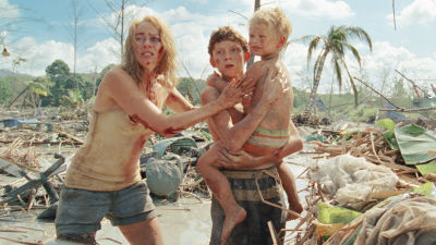 På bilden syns efterspelet av tsunamin i filmen The Impossible. Naomi Watts står intill Tom Holland som håller i ett litet barn i famnen.