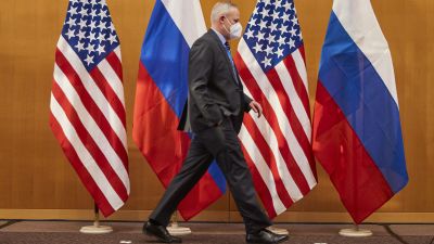 Personen går framför USA:s och Rysslands flaggor.