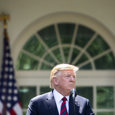 President Trump framför Vita huset i solsken