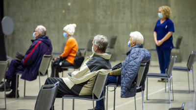Äldre personer i munskydd väntar på coronavaccin i Borgå i mars 2021.