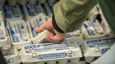 Mataffär, hand sträcker sig efter ett paket ägg.