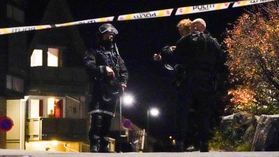 Poliser står på gatan i Norge. En banderoll med texten "Polis" på går tvärs över gatan.