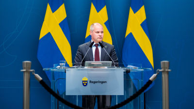 Morgan Johansson med Sveriges flaggor i bakgrunden.