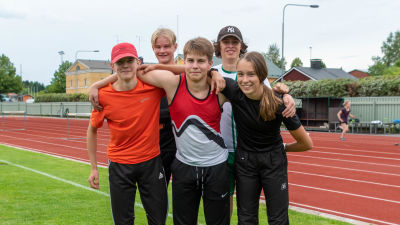 Fem stycken unga idrottare ler mot kameran