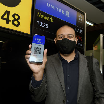 Passagerare visar upp sin mobil. Där syns en QR-kod som bevisar att han testat negativt för covid-19.