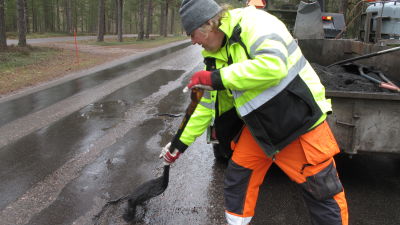 Man reparerar hål i gata.