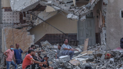 Palestinier som letade efter överlevande vilade på husruiner i Gaza City på söndag morgon.