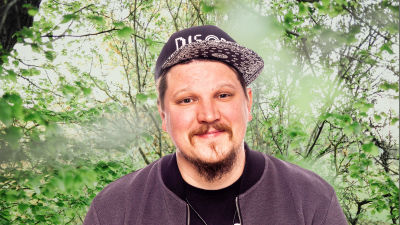 Benjamin Särkkä småler rakt in i kameran. Bakgrunden är en grönskande skogsdunge.