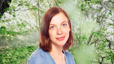 Li Andersson småler in i kameran. Bakgrunden är en grönskande skogsdunge.